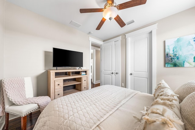 bedroom with dark hardwood / wood-style flooring and ceiling fan