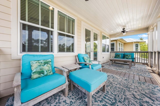 wooden deck with a porch, an outdoor living space, and ceiling fan