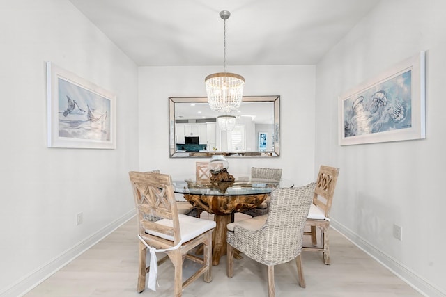 dining area featuring an inviting chandelier and light wood-type flooring