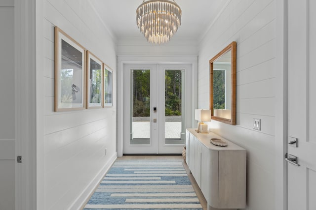 entryway with crown molding, french doors, and a notable chandelier