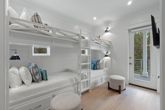 bedroom featuring multiple windows, ornamental molding, access to outside, and light wood-type flooring