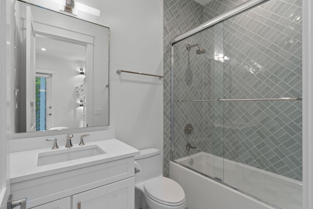 full bathroom featuring vanity, bath / shower combo with glass door, and toilet