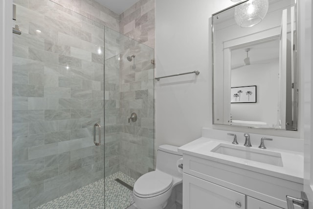 bathroom with vanity, a shower with shower door, and toilet