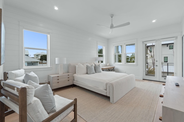 bedroom featuring ceiling fan, light hardwood / wood-style floors, multiple windows, and access to outside