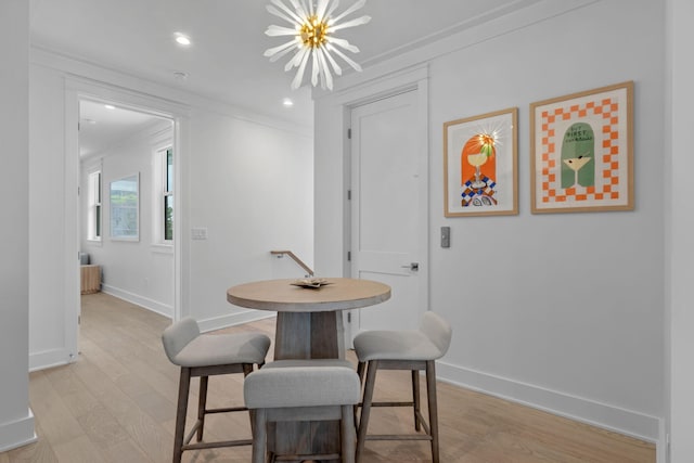 dining room featuring ornamental molding, a chandelier, and light wood-type flooring