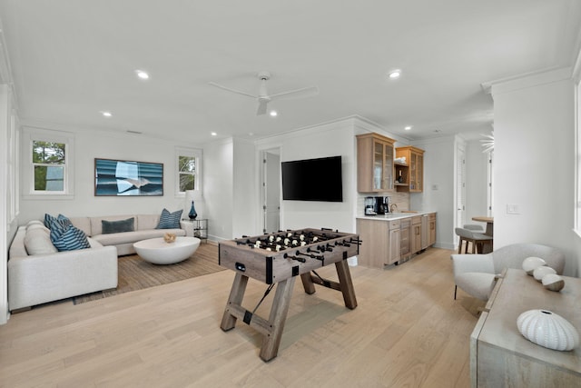 rec room featuring crown molding, a wealth of natural light, and light hardwood / wood-style flooring