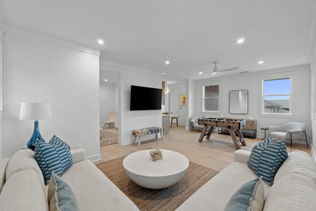 living room featuring crown molding, ceiling fan, and light hardwood / wood-style floors