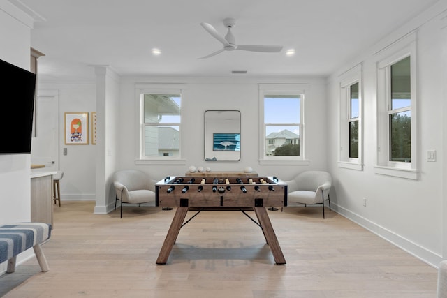 playroom featuring crown molding, ceiling fan, and light wood-type flooring