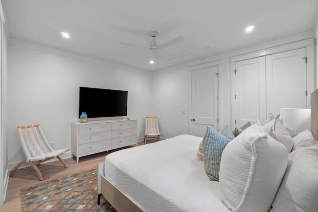 bedroom with hardwood / wood-style flooring, ceiling fan, crown molding, and a closet