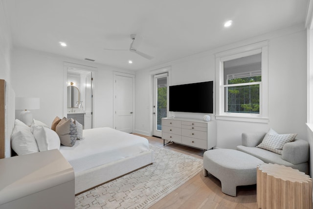 bedroom featuring ensuite bath, access to exterior, light hardwood / wood-style floors, and multiple windows