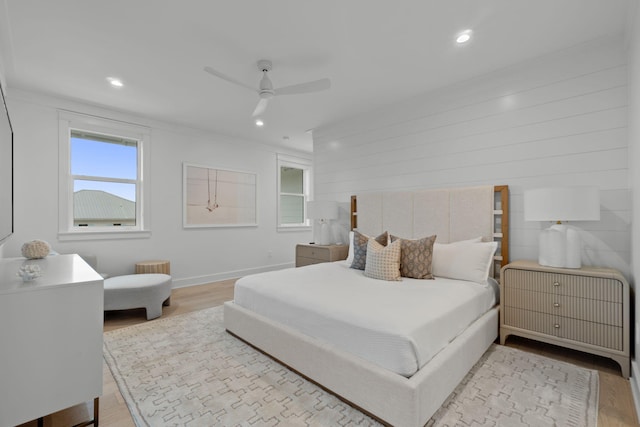 bedroom featuring ceiling fan, ornamental molding, multiple windows, and light wood-type flooring