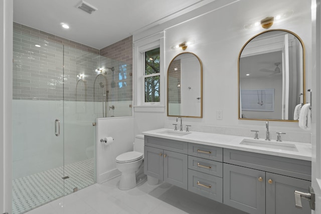 bathroom with a shower with door, vanity, and toilet