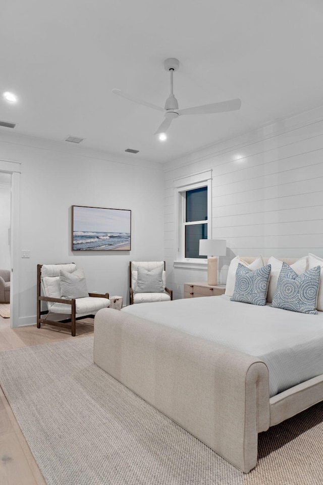 bedroom featuring ornamental molding, ceiling fan, and light hardwood / wood-style flooring