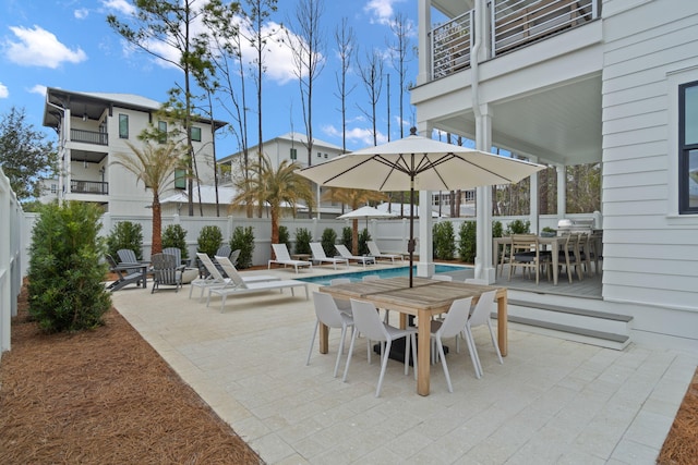 view of patio / terrace featuring a community pool and a balcony