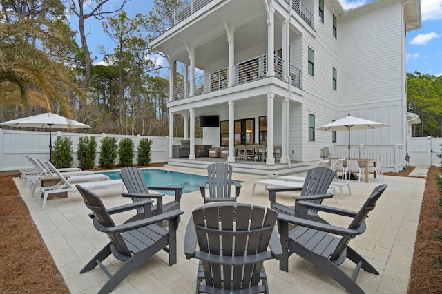 exterior space featuring a balcony and a fenced in pool