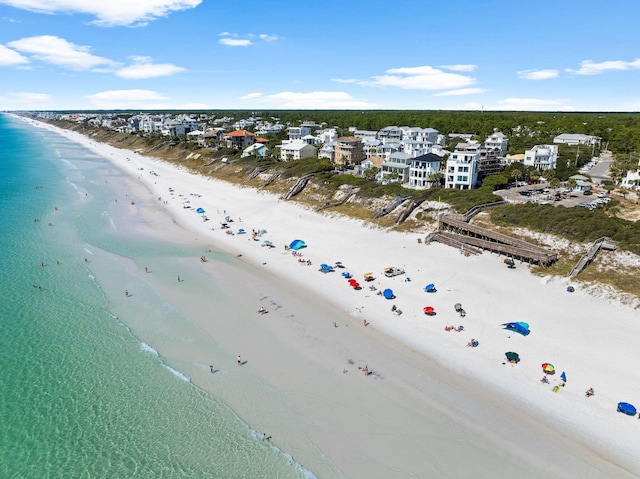 birds eye view of property with a water view and a beach view