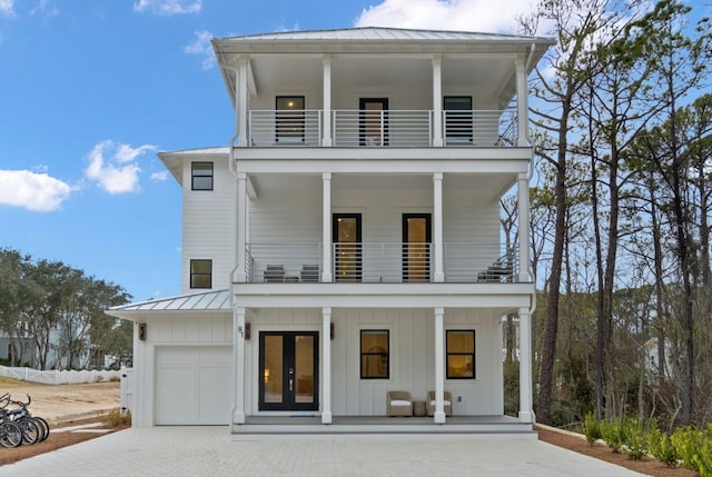 view of front of home with french doors, a balcony, and a porch