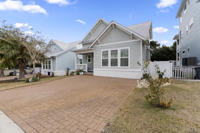 view of front of home with a front yard and central AC unit