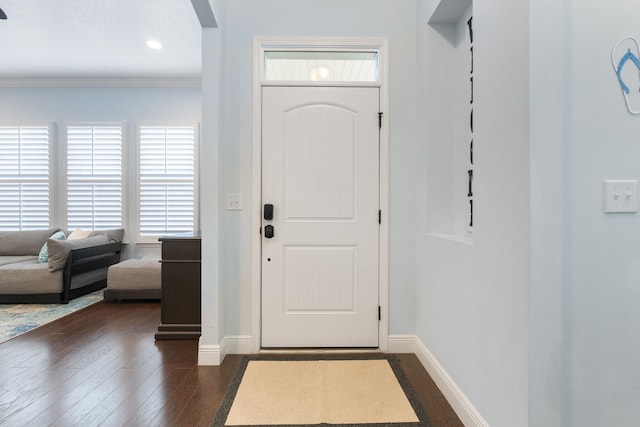 entryway featuring ornamental molding and dark hardwood / wood-style flooring