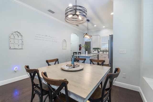 dining space with ornamental molding and dark hardwood / wood-style flooring