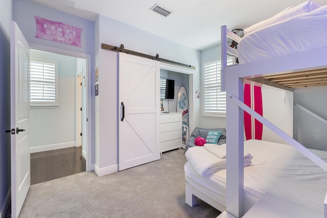 bedroom featuring carpet flooring and a barn door