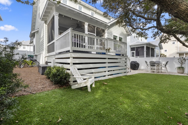 rear view of property with central AC unit, a sunroom, a lawn, ceiling fan, and a patio