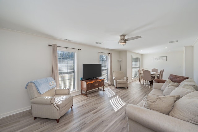 living room with ceiling fan, ornamental molding, and light hardwood / wood-style floors