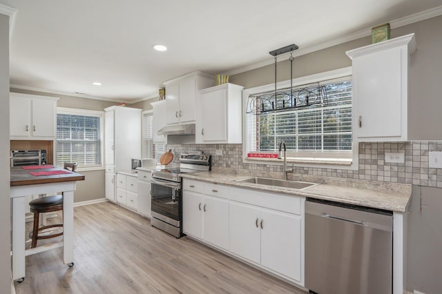 kitchen with white cabinetry, sink, hanging light fixtures, stainless steel appliances, and plenty of natural light