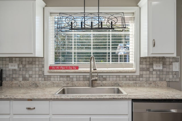 kitchen with stainless steel dishwasher, a healthy amount of sunlight, sink, and white cabinets