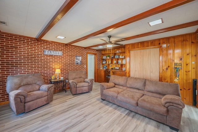 living room featuring brick wall, wooden walls, beamed ceiling, and light wood-type flooring