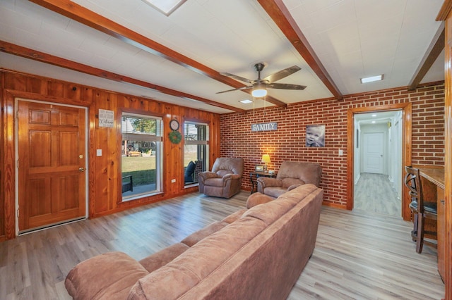 living room with beamed ceiling, brick wall, ceiling fan, and light hardwood / wood-style flooring