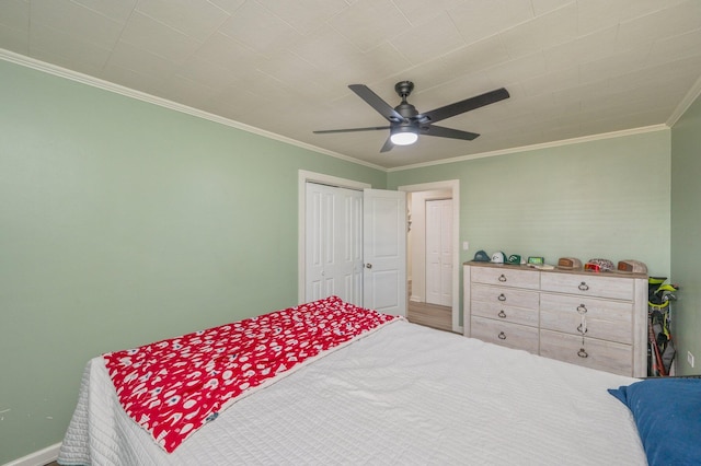 bedroom with ceiling fan, ornamental molding, and a closet