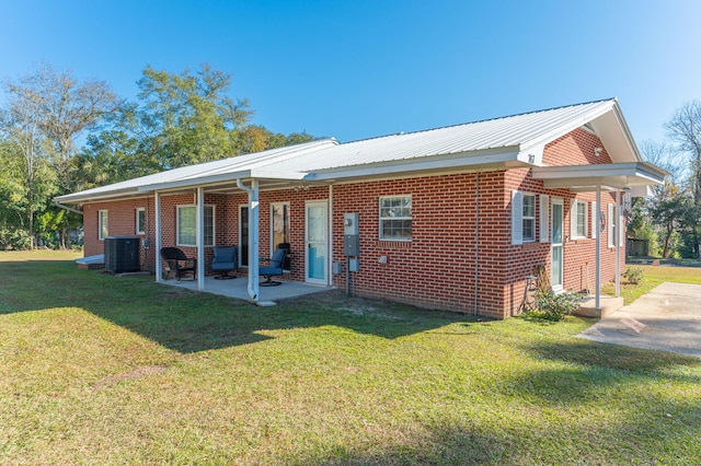 back of house featuring cooling unit, a lawn, and a patio area