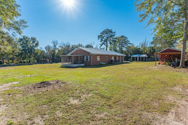 view of yard featuring a carport and a sunroom