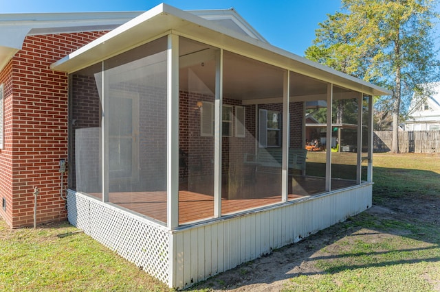 view of property exterior featuring a lawn and a sunroom