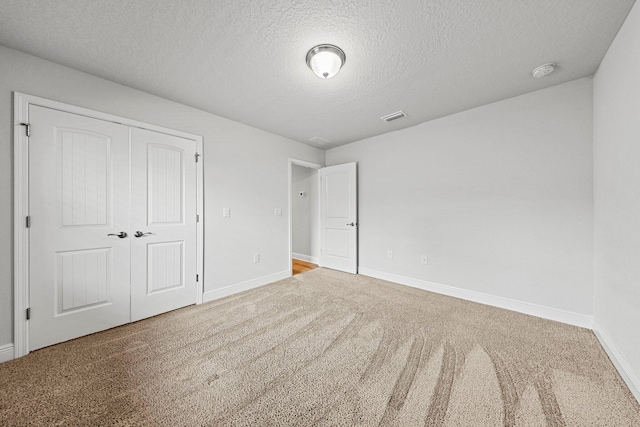 unfurnished bedroom featuring a closet, carpet, and a textured ceiling