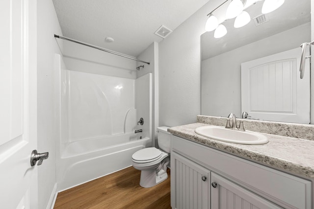 full bathroom featuring toilet, a textured ceiling, vanity, hardwood / wood-style flooring, and shower / bath combination