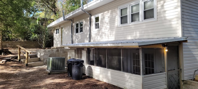 view of side of property featuring a sunroom and central AC