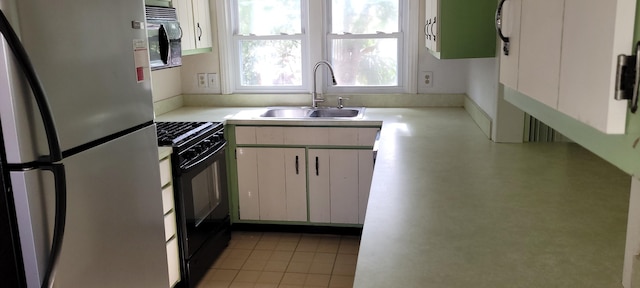 kitchen featuring white cabinetry, sink, light tile patterned floors, and black appliances