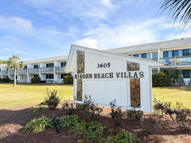 community sign featuring a lawn