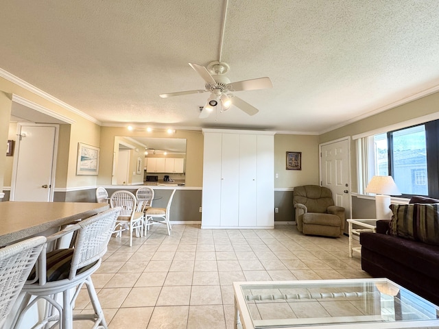 living room featuring crown molding, light tile patterned floors, ceiling fan, and a textured ceiling