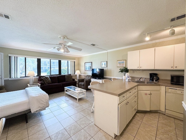 kitchen with dishwasher, sink, white cabinets, light tile patterned floors, and kitchen peninsula