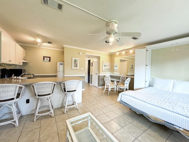 tiled living room featuring sink, crown molding, a textured ceiling, and ceiling fan