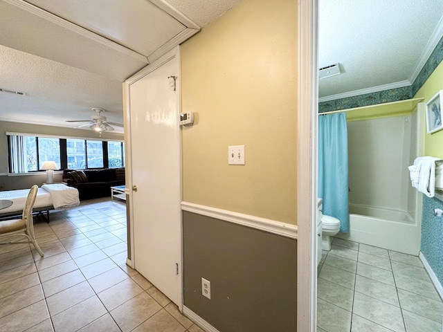 corridor with ornamental molding, a textured ceiling, and light tile patterned flooring