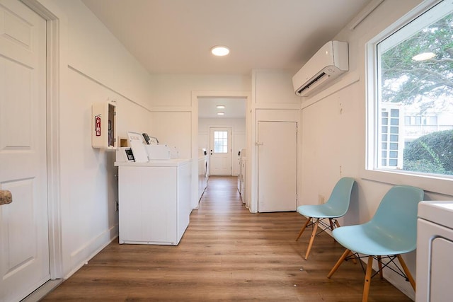 laundry area featuring hardwood / wood-style floors and a wall mounted AC