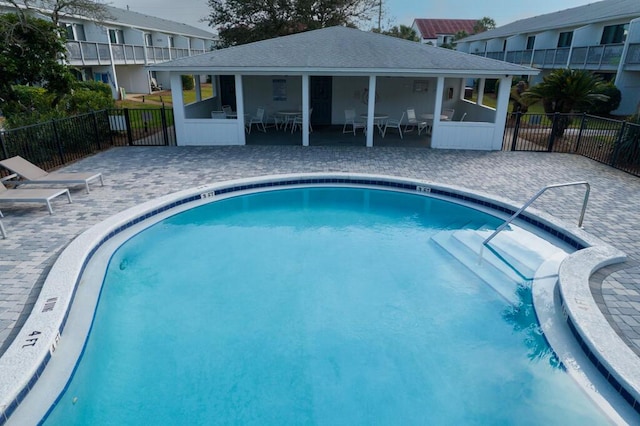 view of pool with a sunroom and a patio