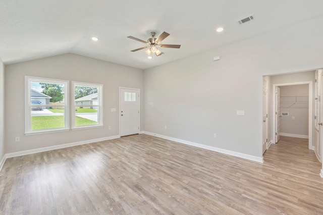 unfurnished living room featuring visible vents, baseboards, light wood-style floors, lofted ceiling, and ceiling fan