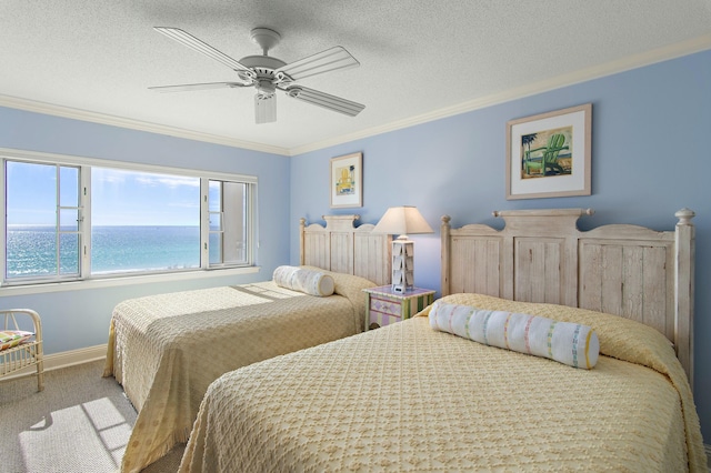 bedroom with a water view, ornamental molding, carpet, and a textured ceiling