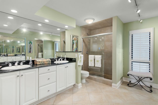 bathroom with tile patterned flooring, vanity, toilet, and walk in shower