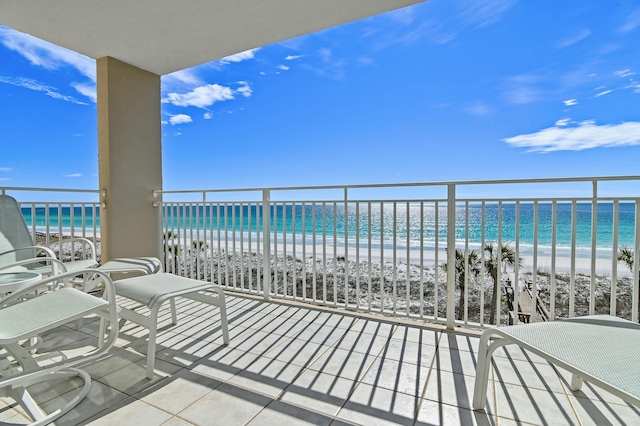 balcony with a water view and a beach view